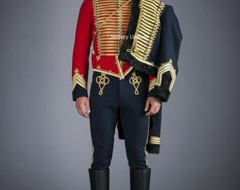 May include: A military uniform featuring a red jacket with gold trim and a high collar, paired with navy blue pants and black boots. A navy blue jacket with gold trim is draped over the shoulder. The uniform is a formal military style.