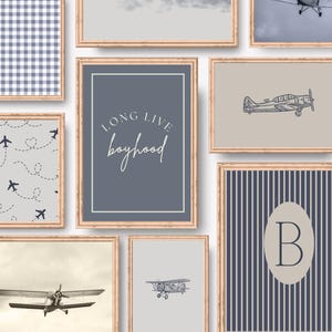 May include: A collection of framed art prints with a vintage aviation theme. Prints include airplane illustrations, cloudscapes, and patterns in shades of blue, gray, and beige. One print features the text "LONG LIVE boyhood".