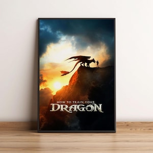 May include: Framed poster featuring a dramatic scene from "How to Train Your Dragon." A silhouetted dragon and a figure stand atop a mountain peak against a sunset backdrop. The movie title is displayed in a stylized font.