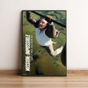 May include: A framed movie poster for "Mission: Impossible - The Final Reckoning" showing a man suspended from a cable against a green backdrop. The poster features the film title in white text on the left.