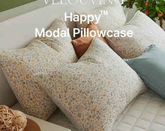 May include: Several floral-patterned pillowcases in a bedroom setting. The pillowcases are white with a delicate pattern of small flowers in various colors. The text "VELOUVING Happy Modal Pillowcase" is displayed on the image.