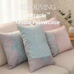May include: Four decorative Modal pillowcases in shades of blue, pink, and gray, arranged on a cream-colored sofa. The pillowcases feature a geometric diamond pattern. The text "VELOUVING Miracle Modal Pillowcase" is visible.