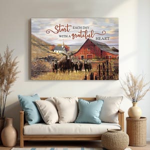 May include: A rustic wooden wall art piece featuring a pastoral scene with a red barn, a white church, and a herd of cows. The artwork includes the text "Start each day with a grateful heart" in elegant script, evoking a sense of country living.