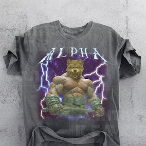 May include: A gray t-shirt with a vintage-style graphic of a muscular wolf with lightning bolts and the word "ALPHA" in a bold font.