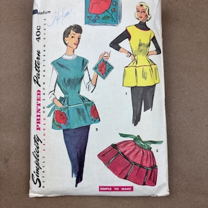 May include: Vintage Simplicity printed sewing pattern, featuring illustrations of aprons and a floral design. The pattern includes the number 4492 and the text "Simple to Make."