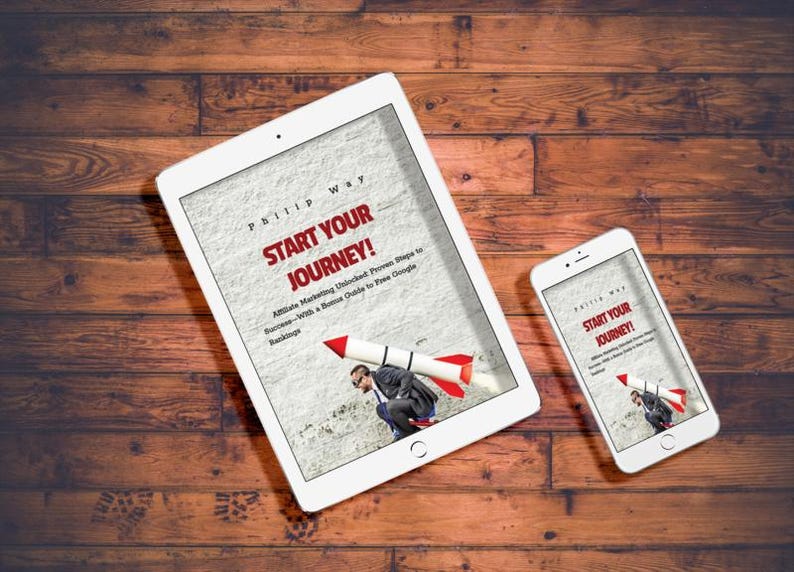 May include: A white tablet and smartphone displaying the book cover "Start Your Journey!" on a wooden surface. The book cover features a man with a rocket strapped to his back. The background is a light gray texture.