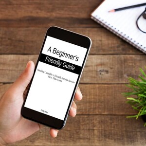 Op de afbeelding: Een smartphone toont de tekst "A Beginner's Friendly Guide". De ondertitel van de gids luidt "Smoking Cannabis: A Friendly Introduction for First-Time Users". De telefoon wordt in een hand gehouden, met een houten achtergrond.