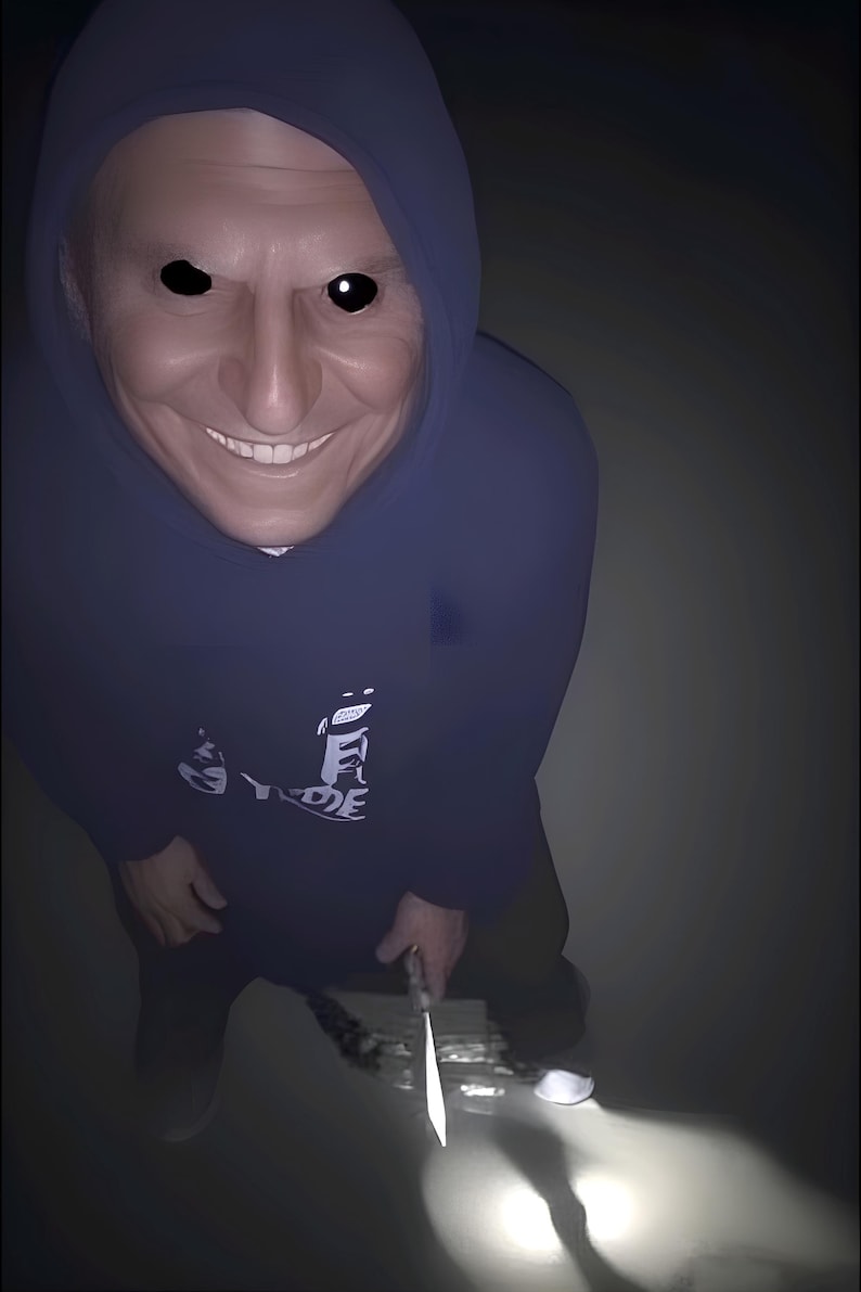 May include: A digitally altered image of a person wearing a dark blue hooded sweatshirt with a white graphic. The person has a distorted face with black eyes and a wide smile, holding a knife.