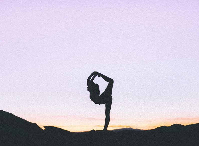 Pu&ograve; includere: Silhouette di una persona in posa yoga contro un cielo crepuscolare. La figura &egrave; in una posa dell'arco in piedi, con una gamba estesa e l'altra piegata, che raggiunge il piede. Lo sfondo presenta una sfumatura di colori.
