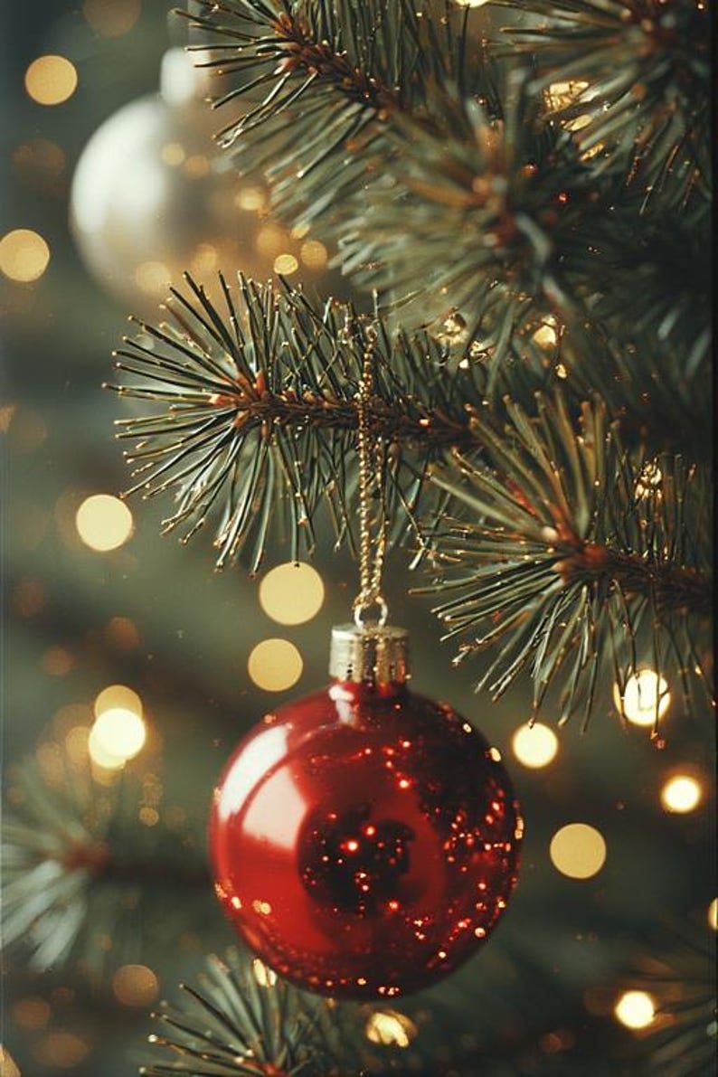May include: A close-up of a Christmas tree branch with a shiny red ornament hanging from a gold chain. The ornament reflects the surrounding lights. The background is blurred with bokeh lights, creating a festive holiday scene.