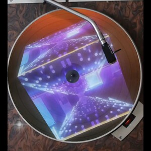 May include: A vintage record player with a turntable playing a record with a holographic image of a cube with a purple and blue design.