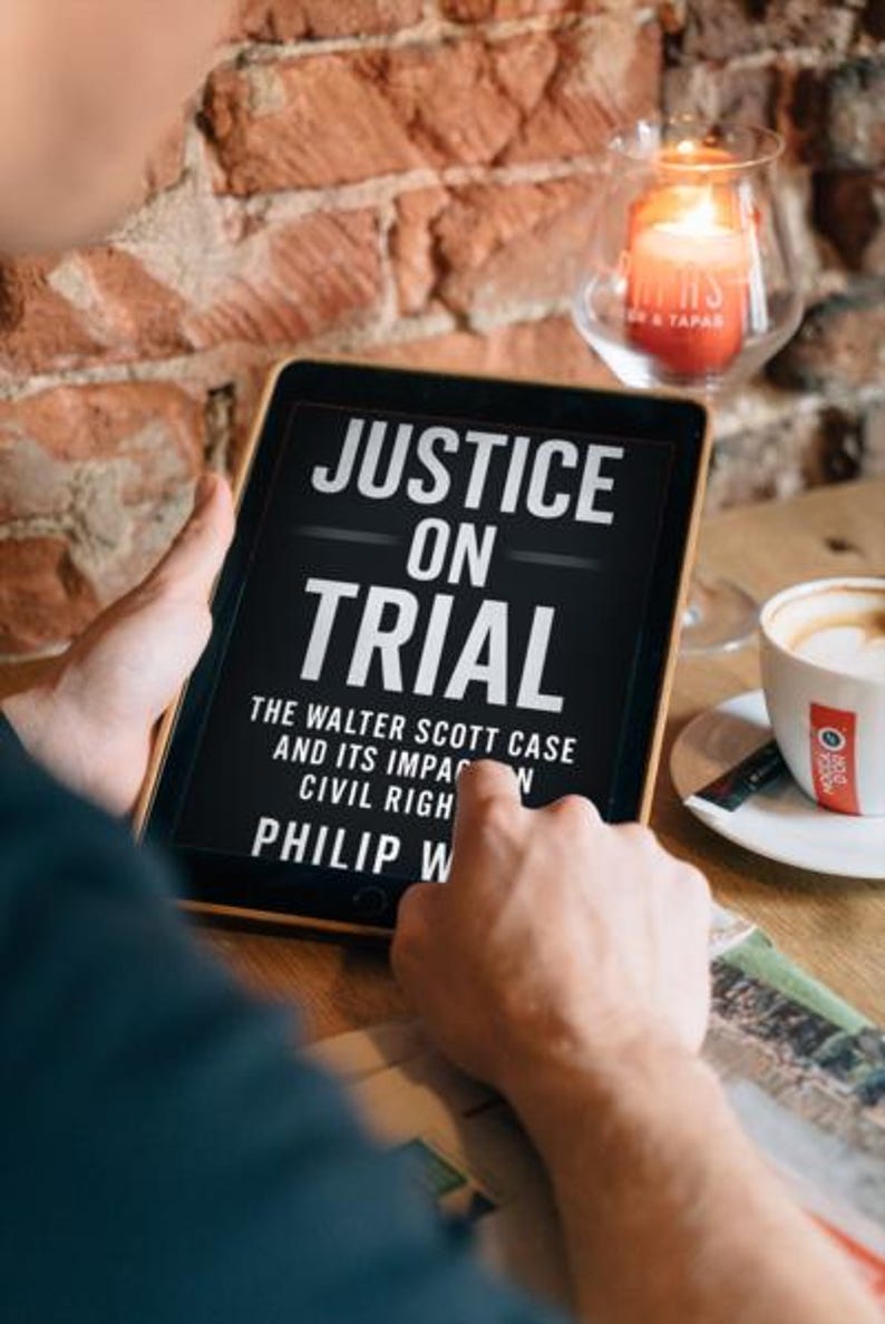 May include: A tablet displaying the book cover of "Justice on Trial" by Philip W. The cover features white text on a black background. A cup of coffee and a lit candle are also visible in the image.