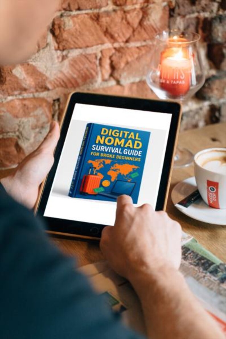 Op de afbeelding: Een tablet toont de omslag van een boek getiteld "DIGITAL NOMAD SURVIVAL GUIDE FOR BROKE BEGINNERS". De omslag is blauw met illustraties van een koffer, wereldkaart, laptop en geld. Een kopje koffie en een brandende kaars zijn ook zichtbaar.