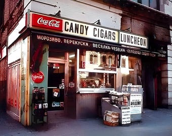 May include: A storefront with a red Coca-Cola sign and a yellow sign that reads "CANDY CIGARS LUNCHEON". The storefront has a large window with a display of goods inside. The storefront is located on a city street.