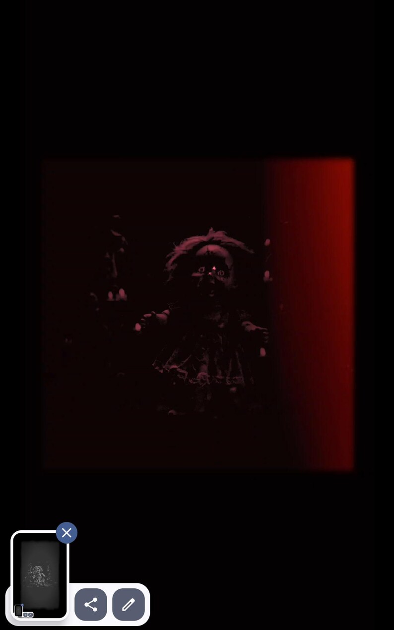 Puede incluir: Imagen oscura y siniestra de una mu&ntilde;eca con ojos brillantes, sobre un fondo negro con una franja vertical roja. La mu&ntilde;eca tiene el pelo desordenado y una expresi&oacute;n siniestra, creando una atm&oacute;sfera espeluznante.