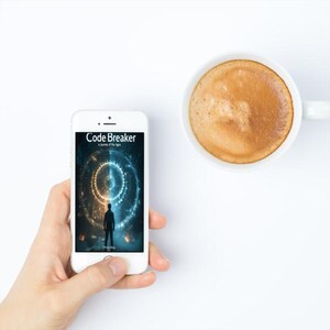 May include: A white smartphone displaying the cover of "Code Breaker: A Journey of the Lights" with a silhouette of a person. A white coffee mug with a brown beverage is next to the phone. The background is white.