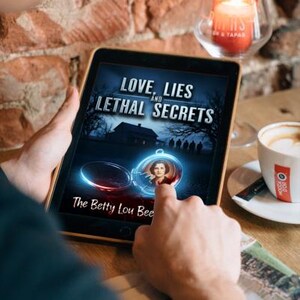 K&ouml;nnte beinhalten: Ein Tablet zeigt das Buchcover von "Love, Lies, and Lethal Secrets" von The Betty Lou Bee. Das Cover zeigt ein Spukhaus, Schattenfiguren und ein Medaillon mit einem Frauenportr&auml;t. Eine brennende Kerze und eine Kaffeetasse sind im Hintergrund zu sehen.