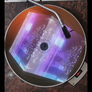 May include: A vintage record player with a turntable and a tonearm. The turntable is playing a record with a holographic cube design that is glowing with purple and blue lights.