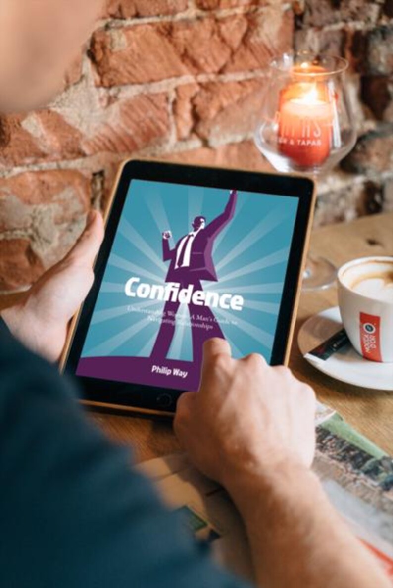 以下が含まれることがあります： フィリップ・ウェイ著「Confidence」の表紙が表示されたタブレット。表紙には、腕を上げたスーツ姿の男性の様式化されたイラストが描かれています。背景には、火の灯ったろうそくとコーヒーカップが見えます。