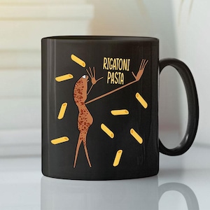 May include: Black ceramic mug with a humorous design. It features a cartoon pasta character with arms outstretched, surrounded by rigatoni pasta shapes. The text "RIGATONI PASTA" is written on the mug. The mug has a black handle.