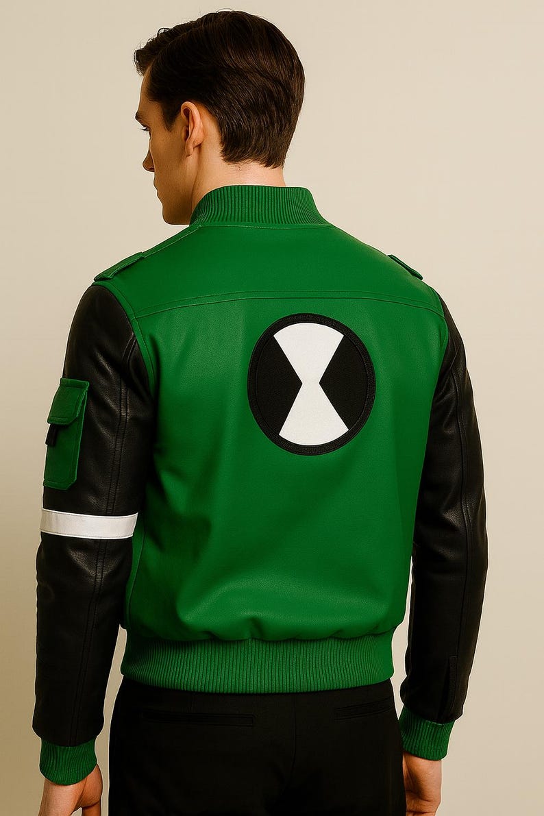 May include: Green and black bomber jacket featuring a white and black graphic on the back. The jacket has black sleeves, a green body, and a white stripe on the left sleeve. It has a ribbed collar and cuffs.