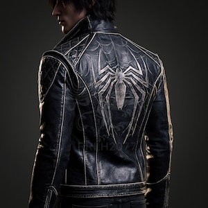 May include: A black leather jacket featuring a large silver spider emblem on the back, surrounded by a subtle spiderweb pattern. The jacket includes quilted shoulder panels, a high collar, and visible stitching details throughout the garment.