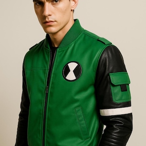 May include: Green and black bomber jacket with a white and black circular patch on the chest. The jacket has black sleeves with a white stripe and a green pocket. The jacket is zipped up.