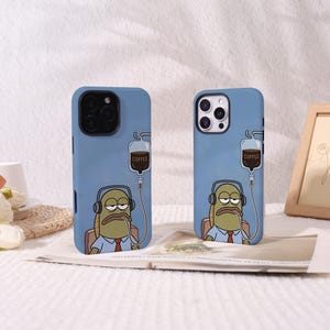 May include: Two blue smartphone cases featuring a cartoon character wearing headphones and a light blue shirt with a red tie. The character is connected to an intravenous drip bag labeled COFFEE, with a tube extending to the character's mouth.