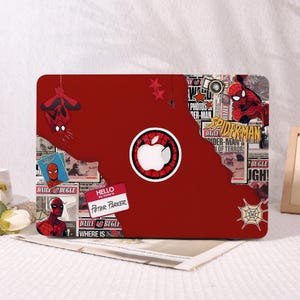 May include: A red laptop skin featuring Spider-Man graphics. The design includes comic book-style elements, the Daily Bugle newspaper, and a name tag that reads "Hello my name is Peter Parker." The Apple logo is integrated into the design.