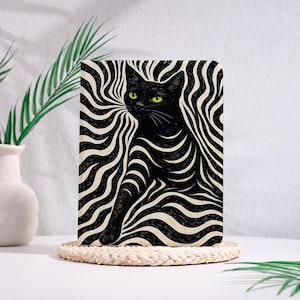 Könnte beinhalten: Illustration einer schwarzen Katze mit grünen Augen vor einem schwarz-weißen Wellenhintergrund. Die Katze sitzt aufrecht, mit einer ausgestreckten Vorderpfote. Das Kunstwerk befindet sich auf einem rechteckigen Notizbuch oder Druck.