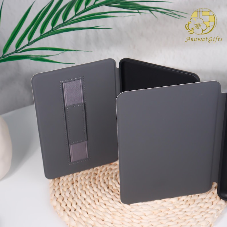 Pode incluir: Capa cinza para tablet com suporte integrado. A capa est&aacute; aberta, revelando um interior preto. Uma faixa el&aacute;stica cinza &eacute; vis&iacute;vel no interior. A capa est&aacute; sobre uma esteira tecida.