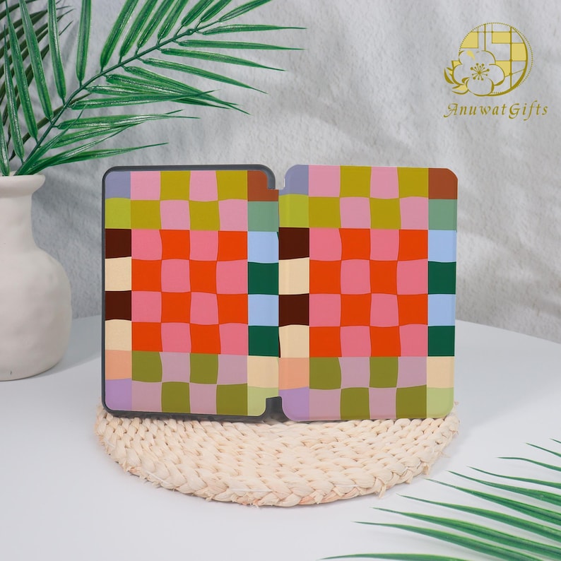 Pode incluir: Uma capa estampada com um design xadrez em tons de rosa, laranja, verde, azul e castanho. A capa est&aacute; aberta. O fundo inclui um vaso branco, um tapete tecido e um logotipo que diz "Anuwat Gifts".