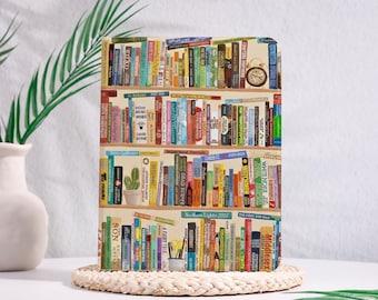 May include: A rectangular tablet case featuring a colorful illustration of three stacked wooden bookshelves filled with various books of different sizes and colors, including a small potted cactus and a vintage alarm clock on the shelves.