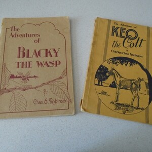 May include: Two vintage children's books. The book on the left is titled "The Adventures of Blacky the Wasp" by Chas. G. Robinson. The book on the right is titled "The Adventures of Keo the Colt" by Charles Elmo Robinson. Both books have a tan cover.