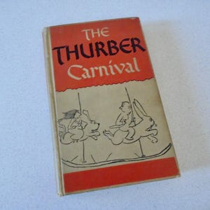 May include: A vintage book titled "The Thurber Carnival" with a red and cream cover. The cover features the title in black and red lettering, and a black and white illustration of figures riding carousel animals.