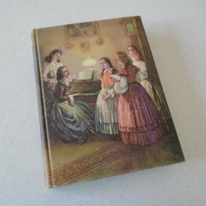 May include: Vintage hardcover book with a detailed illustration of women in period clothing gathered around a piano. The cover art features a warm color palette with figures in long dresses, creating a scene of domestic life.