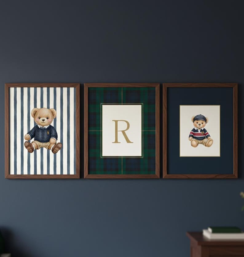 May include: Three framed prints featuring teddy bear illustrations. One print has a teddy bear in a blue sweater against a striped background. Another has a letter "R" on a plaid background. The third print has a teddy bear in a striped shirt.