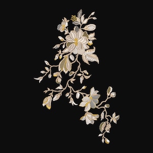 Puede incluir: Diseño floral bordado con flores, hojas y tallos crema y dorados sobre fondo negro. El bordado detallado muestra patrones y texturas intrincados, creando una estética delicada y elegante. Adecuado para diversos proyectos de manualidades.