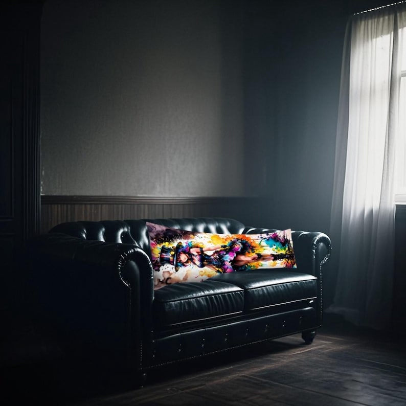 May include: A black leather sofa with a rectangular body pillow featuring abstract art. The pillow displays a vibrant mix of colours, including purple, yellow, and blue. The room has dark walls and a window with sheer curtains.