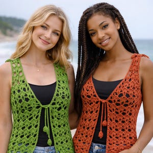 Può includere: Due donne indossano gilet all'uncinetto fatti a mano. Uno è verde brillante, l'altro è arancione bruciato. Entrambi i gilet hanno uno scollo a V e una chiusura con lacci. I gilet sono indossati sopra top neri. Lo sfondo è una scena di spiaggia.