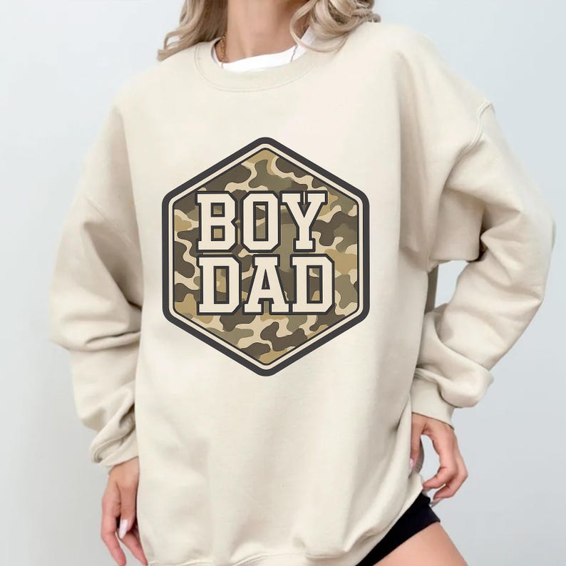 a woman wearing a sweatshirt that says boy dad