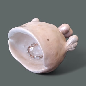 以下が含まれることがあります： 小さなリングが入った、クジラの形をした白いセラミック製のリングホルダーです。