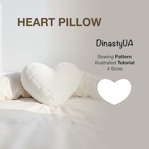 Könnte beinhalten: Ein flauschiges, weißes herzförmiges Kissen liegt auf einem Bett. Das Bild enthält den Text "HEART PILLOW" oben und "DinastyUA Sewing Pattern Illustrated Tutorial 4 Sizes" auf der rechten Seite. Das Kissen hat ein weiches, plüschiges Design.