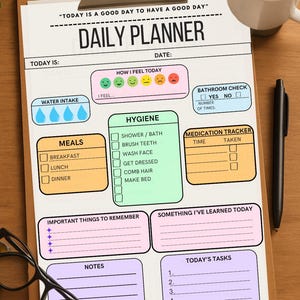 A daily planner with a light blue, pink, and green color scheme. The planner includes sections for water intake, meals, hygiene, bathroom check, medication tracker, important things to remember, something I've learned today, notes, and today's tasks. The planner has a title that reads 'Today is a good day to have a good day' and 'Daily Planner'.