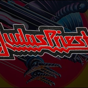 May include: Embroidered patch with the words "Judas Priest" in red, with a white outline, on a black background. The patch has a stitched border. The background features a stylized eagle and claw design.