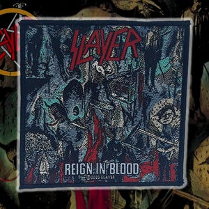 Puede incluir: Una taza de cerámica blanca con asa negra y el texto "But First, Coffee" en negrita negra. La taza se encuentra sobre un fondo borroso, sugiriendo un ambiente acogedor.