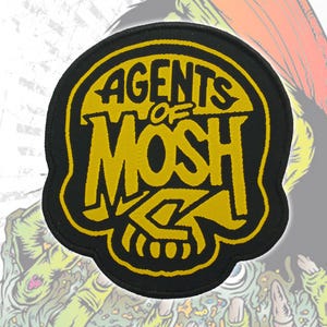 May include: A black and yellow patch with the words "AGENTS OF MOSH" in a stylized font, set against a skull design. The patch has a black border and a yellow interior.