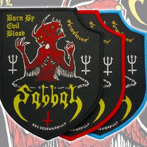 以下が含まれることがあります： 赤い悪魔のグラフィックと「Born By Evil Blood」「Sabbat」「P&C 2026 WHOKULT」の文字が刺繍された、盾型のワッペン3枚。それぞれ黒、赤、青の縁取りが施され、両側に白い三叉の矛のシンボルがデザインされています。