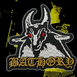Könnte beinhalten: Gestickter Aufnäher mit einer schwarzen, ziegenartigen Figur mit roten Augen und weißen Details. Das Wort "BATHORY" ist in goldfarbenen gotischen Buchstaben gestickt. Auf schwarzem Hintergrund mit gelben Akzenten.