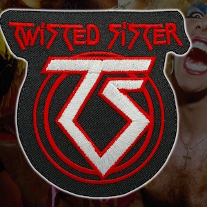 Könnte beinhalten: Gestickter Aufnäher mit den roten Worten "TWISTED SISTER", oben gebogen. Darunter befindet sich ein stilisiertes "TS"-Logo in Weiß, rot umrandet, auf schwarzem Hintergrund. Der Aufnäher hat eine einzigartige Form.